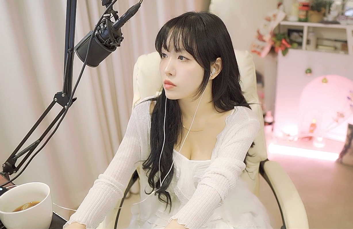 Yuni with black hair and ice coffee in a white cup on her desk